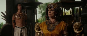 Movie still from “Exodus: Gods and Kings” (2014), directed by Ridley Scott – A woman dressed as cleopatra holding a golden mask; Close Up shot, Over the shoulder angle