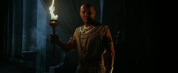 Movie still from “Exodus: Gods and Kings” (2014), directed by Ridley Scott – A man holding a torch in a dark room; Medium shot, Low angle