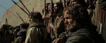 Movie still from “Exodus: Gods and Kings” (2014), directed by Ridley Scott – A group of men standing next to each other holding wooden sticks; Medium shot, Low angle