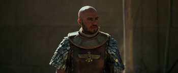 Movie still from “Exodus: Gods and Kings” (2014), directed by Ridley Scott – A bald man wearing a leather and metal outfit; Close Up shot, Over the shoulder angle