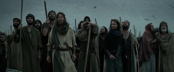 Movie still from “Exodus: Gods and Kings” (2014), directed by Ridley Scott – A group of men standing next to each other holding sticks; Medium shot, Low angle