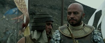 Movie still from “Exodus: Gods and Kings” (2014), directed by Ridley Scott – Two men dressed in ancient roman armor and helmets; Close Up shot, Over the shoulder angle