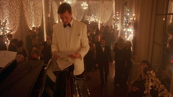 Movie still from “Eyes Wide Shut” (1999), directed by Stanley Kubrick – A man in a white suit standing in front of a piano; Medium shot, Low angle