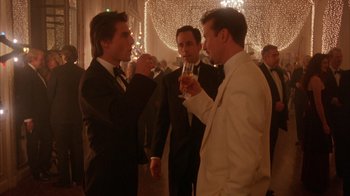 Movie still from “Eyes Wide Shut” (1999), directed by Stanley Kubrick – A group of men standing next to each other holding wine glasses; Medium shot, Over the shoulder angle