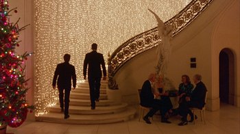 Movie still from “Eyes Wide Shut” (1999), directed by Stanley Kubrick – A group of people sitting on stairs in a room; Wide shot, Low angle