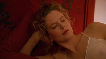 Movie still from “Eyes Wide Shut” (1999), directed by Stanley Kubrick – A woman laying on the ground with her eyes closed; Close Up shot, Overhead angle