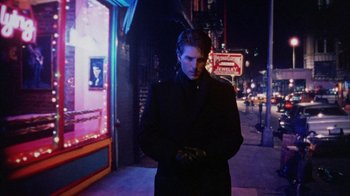 Movie still from “Eyes Wide Shut” (1999), directed by Stanley Kubrick – A man standing on the sidewalk at night in the dark; Medium shot, Low angle
