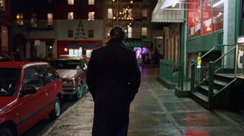 Movie still from “Eyes Wide Shut” (1999), directed by Stanley Kubrick – A man walking down a street at night; Wide shot, Over the shoulder angle