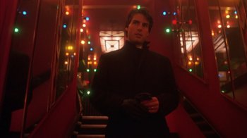 Movie still from “Eyes Wide Shut” (1999), directed by Stanley Kubrick – A man standing on some stairs in a room; Medium shot, Low angle