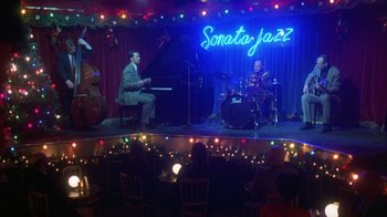 Movie still from “Eyes Wide Shut” (1999), directed by Stanley Kubrick – A couple of people that are sitting in front of a stage; Extreme Wide shot, High angle