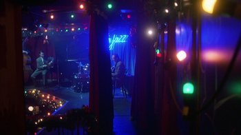 Movie still from “Eyes Wide Shut” (1999), directed by Stanley Kubrick – A man sitting at a table in a room with lights on; Extreme Wide shot, High angle