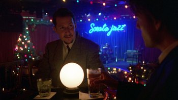 Movie still from “Eyes Wide Shut” (1999), directed by Stanley Kubrick – A man sitting in front of a crystal ball at a table; Medium shot, Over the shoulder angle