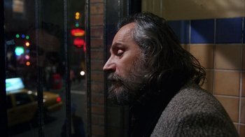 Movie still from “Eyes Wide Shut” (1999), directed by Stanley Kubrick – A man with long grey hair and a beard looking out of a window; Close Up shot, Over the shoulder angle
