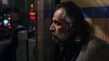 Movie still from “Eyes Wide Shut” (1999), directed by Stanley Kubrick – A man with long hair and a gray beard looking out a window; Close Up shot, Over the shoulder angle