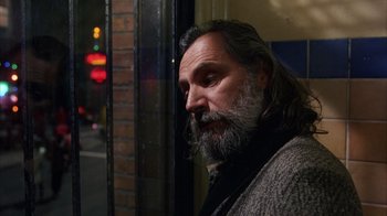 Movie still from “Eyes Wide Shut” (1999), directed by Stanley Kubrick – A man with long hair and a long beard looking out of a window; Close Up shot, Low angle