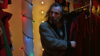 Movie still from “Eyes Wide Shut” (1999), directed by Stanley Kubrick – A man with long hair and a beard standing in a room; Medium shot, Low angle