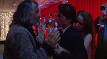 Movie still from “Eyes Wide Shut” (1999), directed by Stanley Kubrick – Two men and a woman in a room; Medium shot, Over the shoulder angle