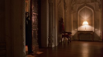 Movie still from “Eyes Wide Shut” (1999), directed by Stanley Kubrick – A person standing in front of an open door in a room; Wide shot, Over the shoulder angle