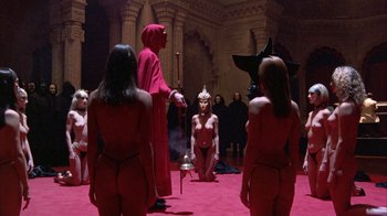 Movie still from “Eyes Wide Shut” (1999), directed by Stanley Kubrick – A group of women in a room with a man in a red robe; Wide shot, High angle