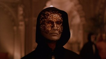 Movie still from “Eyes Wide Shut” (1999), directed by Stanley Kubrick – A man wearing a mask and a black hooded jacket; Close Up shot, Low angle