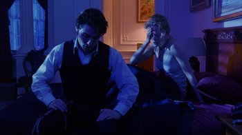 Movie still from “Eyes Wide Shut” (1999), directed by Stanley Kubrick – A man and a woman sitting next to each other on a bed; Medium shot, Low angle