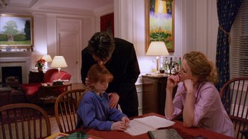 Movie still from “Eyes Wide Shut” (1999), directed by Stanley Kubrick – A woman and a child sitting at a table with an adult; Medium shot, Over the shoulder angle