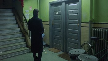 Movie still from “Eyes Wide Shut” (1999), directed by Stanley Kubrick – A man standing in front of a pair of double doors; Wide shot, High angle