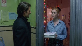 Movie still from “Eyes Wide Shut” (1999), directed by Stanley Kubrick – A man and a woman standing next to each other holding a box; Medium shot, Over the shoulder angle