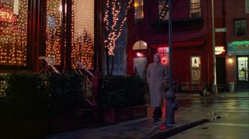 Movie still from “Eyes Wide Shut” (1999), directed by Stanley Kubrick – A man standing on the side of the street next to a fire hydrant; Wide shot, Low angle