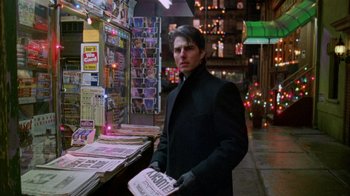 Movie still from “Eyes Wide Shut” (1999), directed by Stanley Kubrick – A man in a black jacket is holding a newspaper; Close Up shot, Over the shoulder angle