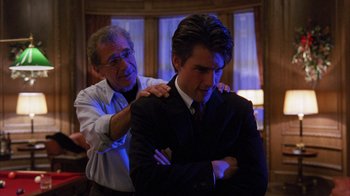 Movie still from “Eyes Wide Shut” (1999), directed by Stanley Kubrick – A man in a suit and a man in a red tie; Medium shot, Over the shoulder angle