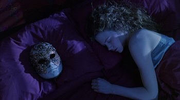 Movie still from “Eyes Wide Shut” (1999), directed by Stanley Kubrick – A woman laying in bed next to a mask; Close Up shot, Overhead angle