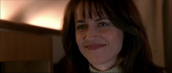 Movie still from “Face/Off” (1997), directed by John Woo – A woman smiling for the camera; Close Up shot, Over the shoulder angle