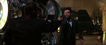 Movie still from “Face/Off” (1997), directed by John Woo – A man in a black suit and a man in a black tie; Medium shot, Over the shoulder angle