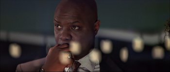 Movie still from “Face/Off” (1997), directed by John Woo – A person wearing a suit and tie; Close Up shot, Low angle