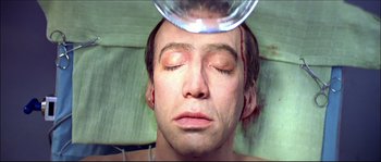 Movie still from “Face/Off” (1997), directed by John Woo – A man is getting his head shaved in a medical procedure; Close Up shot, Overhead angle