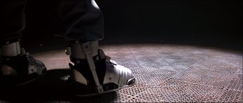 Movie still from “Face/Off” (1997), directed by John Woo – A person's foot wearing a pair of ski boots; Wide shot, Low angle
