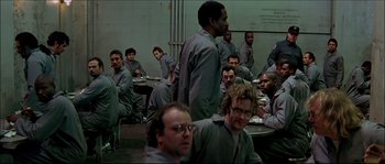Movie still from “Face/Off” (1997), directed by John Woo – A group of men sitting at a table in a room; Wide shot, High angle