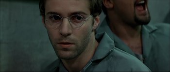 Movie still from “Face/Off” (1997), directed by John Woo – A person wearing glasses; Close Up shot, Over the shoulder angle