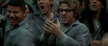 Movie still from “Face/Off” (1997), directed by John Woo – A man with glasses is clapping his hands; Close Up shot, Low angle