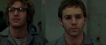 Movie still from “Face/Off” (1997), directed by John Woo – A person wearing glasses; Close Up shot, Low angle