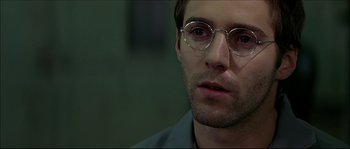 Movie still from “Face/Off” (1997), directed by John Woo – A person wearing glasses; Close Up shot, Over the shoulder angle