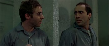 Movie still from “Face/Off” (1997), directed by John Woo – A man with glasses is looking at himself in the mirror; Close Up shot, Over the shoulder angle