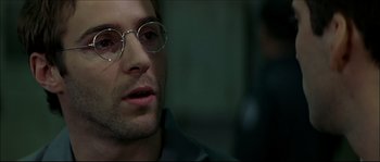 Movie still from “Face/Off” (1997), directed by John Woo – A person wearing glasses; Close Up shot, Over the shoulder angle