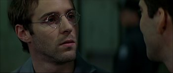 Movie still from “Face/Off” (1997), directed by John Woo – A person wearing glasses; Close Up shot, Over the shoulder angle