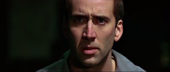 Movie still from “Face/Off” (1997), directed by John Woo – A man's face in a dimly - lit room; Close Up shot, Low angle