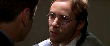 Movie still from “Face/Off” (1997), directed by John Woo – A person wearing glasses; Close Up shot, Over the shoulder angle