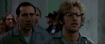 Movie still from “Face/Off” (1997), directed by John Woo – A group of men standing next to each other in a room; Close Up shot, Low angle