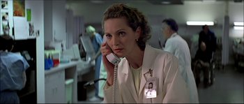 Movie still from “Face/Off” (1997), directed by John Woo – A woman in a white lab coat talking on a phone; Close Up shot, Low angle
