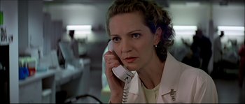 Movie still from “Face/Off” (1997), directed by John Woo – A woman talking on a phone while wearing a white shirt; Close Up shot, Low angle